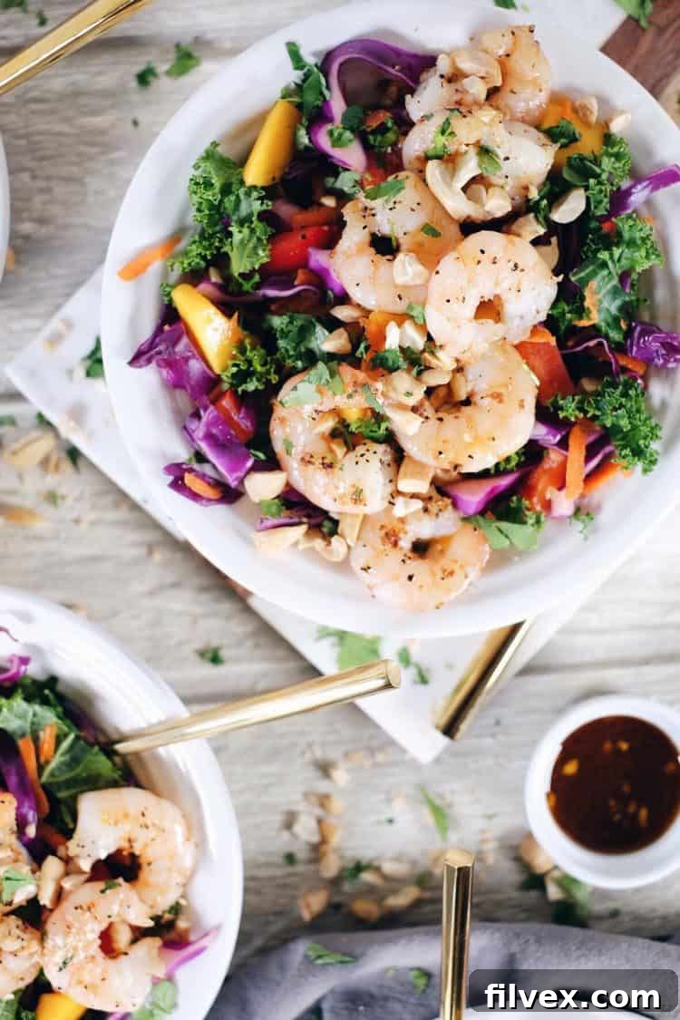 A beautifully chopped Thai shrimp salad, packed with fresh vegetables and shrimp, ready to be served. It's a colorful and inviting dish.