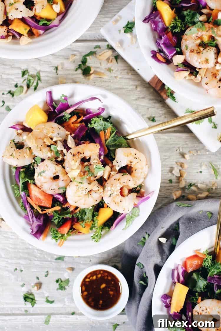 A close-up of the finished Chopped Thai Shrimp Salad, with a fork digging into the colorful mix of veggies and shrimp.