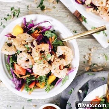 A chopped Thai shrimp salad looks like eating the rainbow! It's packed with kale, cabbage, bell pepper, carrots, mango and cilantro.