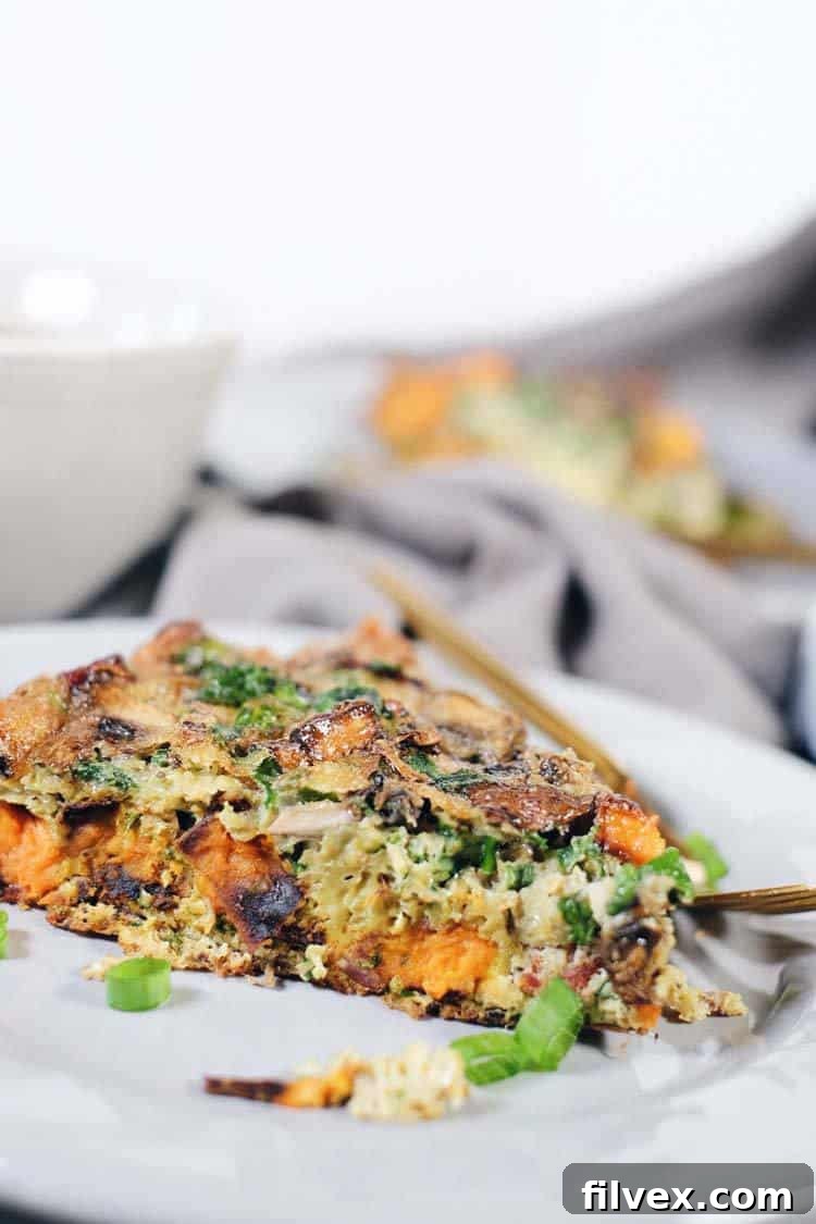 Overhead view of a perfectly baked Bacon Sweet Potato Frittata garnished with fresh herbs. Ideal for Paleo meal prep.