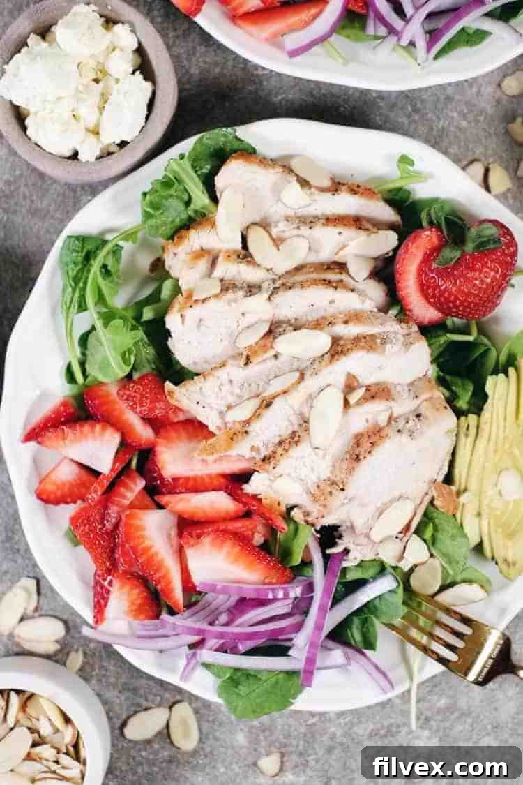 A beautifully plated Strawberry Chicken Salad with succulent chicken, fresh arugula, spinach, bright red strawberries, creamy avocado, and thinly sliced red onion, drizzled with a rich balsamic dressing. This Paleo and Whole30 compliant dish is ready in just 30 minutes.