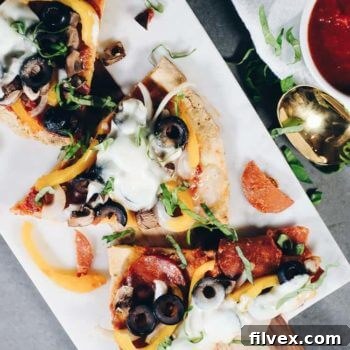 Slices of paleo pizza on a marble cutting board, ready to be enjoyed.
