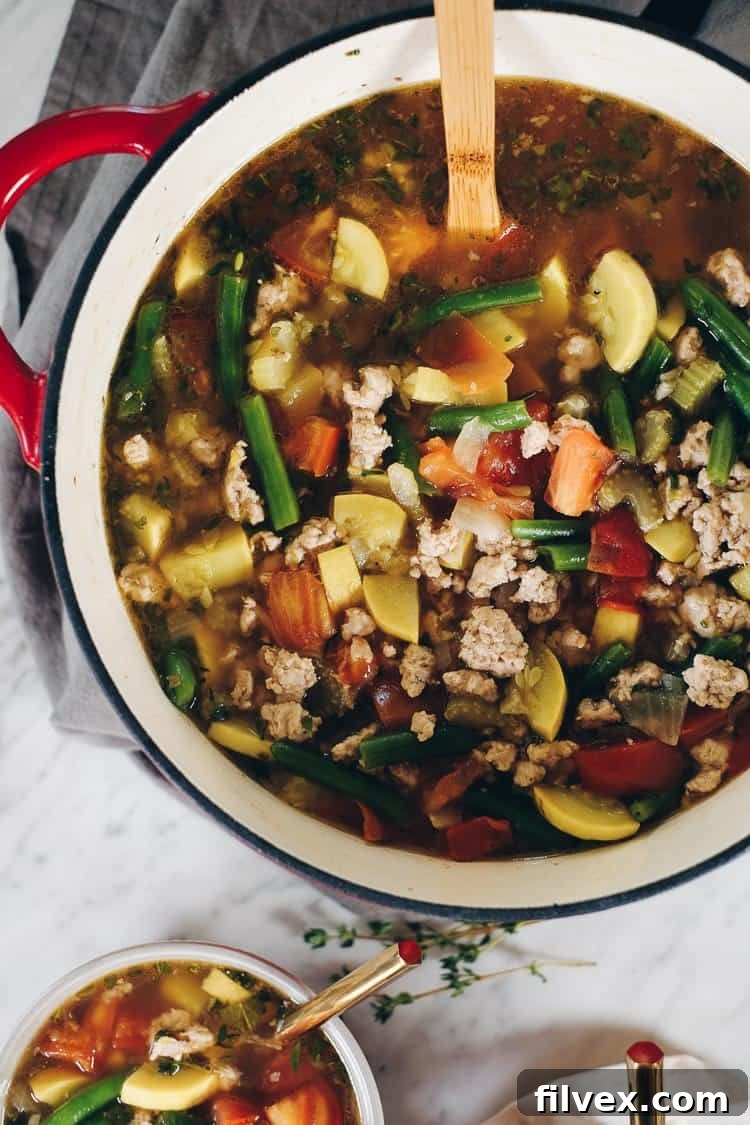 Various fresh herbs like thyme and sage in small pots, ready to be picked and added to a summer vegetable soup, highlighting their aromatic qualities.