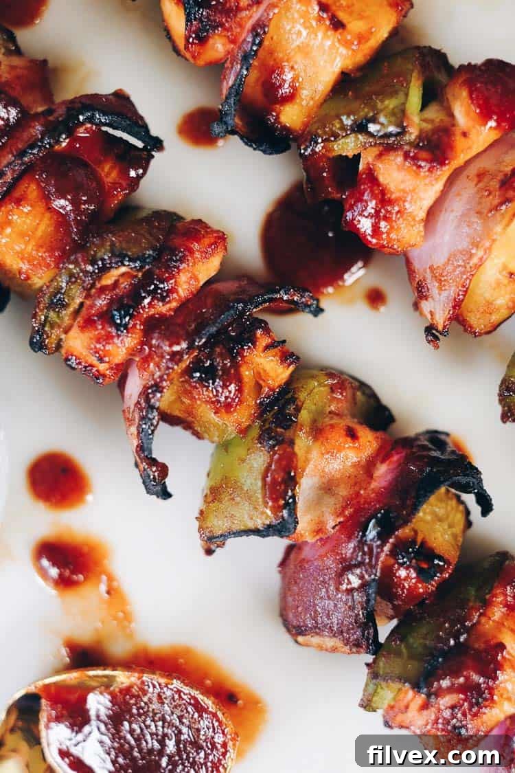 Grilled Hawaiian chicken kabobs sizzling on an outdoor grill, showing grill marks and caramelization.