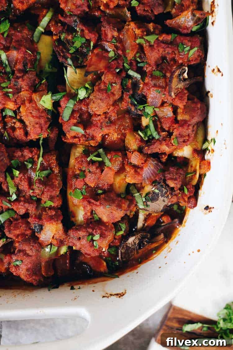Close-up of a serving of Paleo Zucchini Lasagna, showcasing perfectly cooked zucchini noodles, savory ground meat, and a rich tomato sauce. This Whole30 and Keto compliant dish is a testament to flavorful, dairy-free cooking.