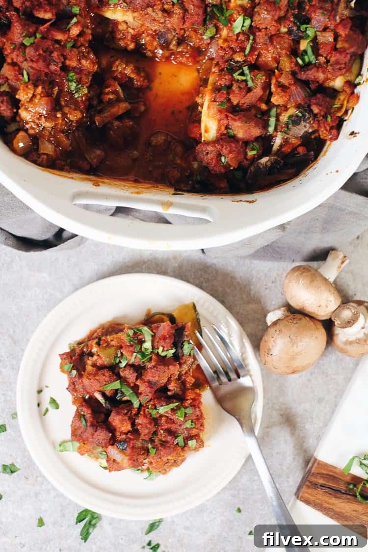 A perfectly portioned slice of Paleo Zucchini Lasagna, garnished with fresh herbs, showcasing its appetizing layers. This dairy-free, low-carb dish is excellent for meal prep and healthy family dinners.