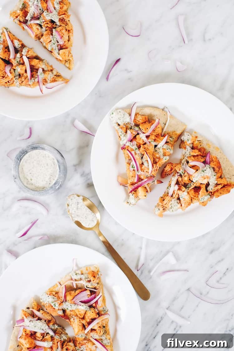 A slice of Buffalo Ranch Chicken Pizza showing the creamy ranch and spicy chicken toppings on a gluten-free crust. | realsimplegood.com
