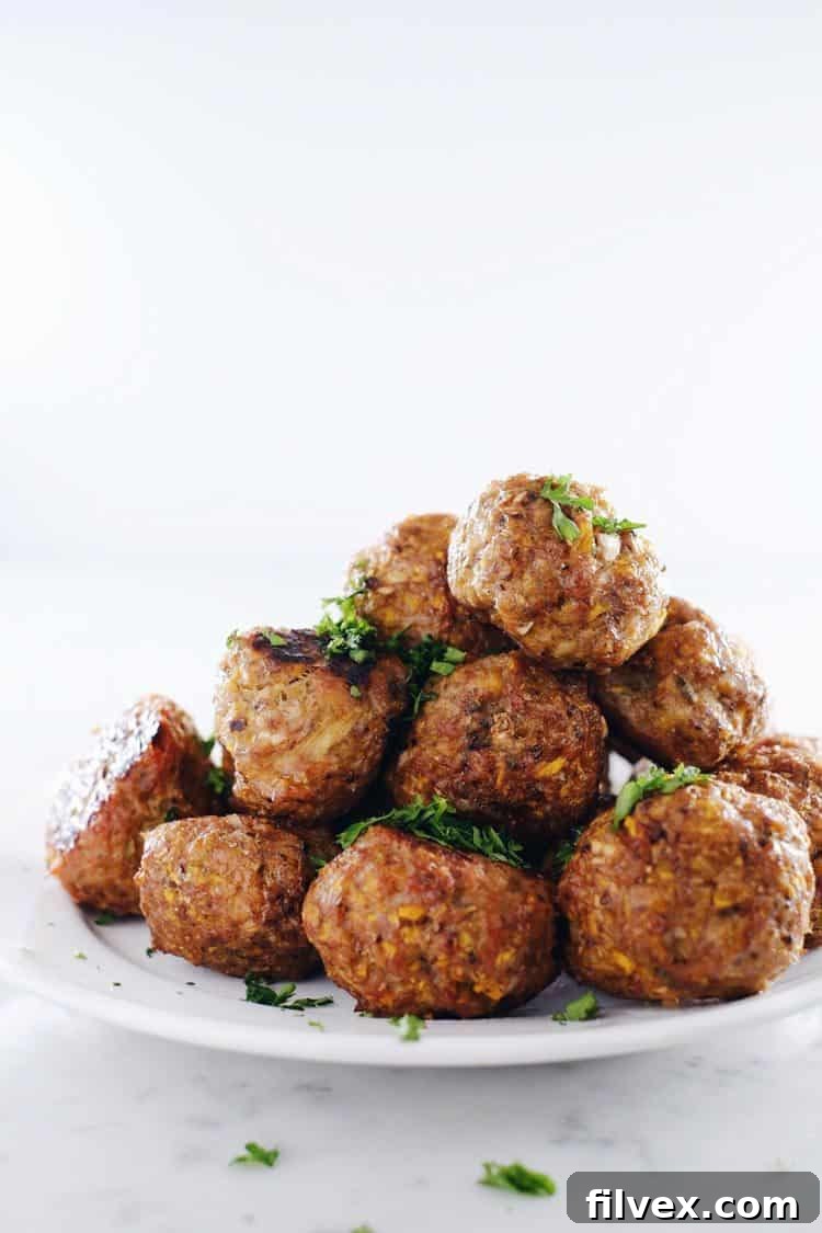 Close-up of golden-brown butternut breakfast meatballs with fresh herbs, a perfect Whole30 egg-free breakfast option.