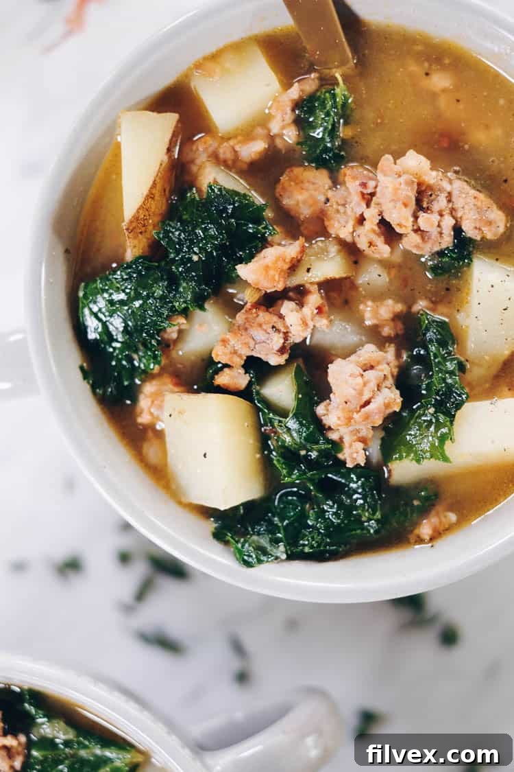 Curling up with a big bowl of this Paleo sausage soup feels so comforting and soul-satisfying. It's filled with roasted garlic, potatoes and kale. Paleo, Whole30 and Dairy-Free.