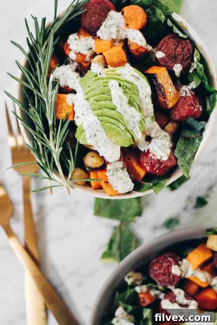Serving suggestion: Sheet Pan Roasted Sausage and Vegetables in a bowl with fresh greens, avocado slices, and a generous drizzle of creamy homemade ranch dressing.