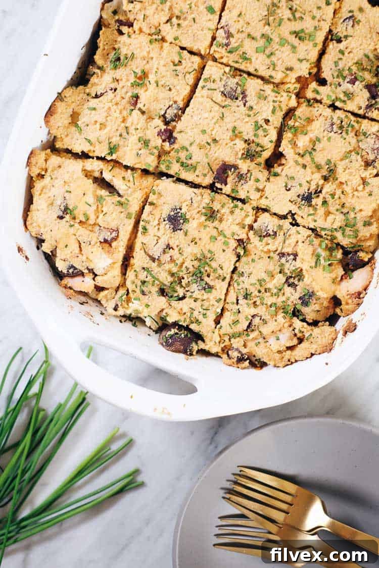 Loaded Cauliflower Casserole overhead in casserole dish, showcasing creamy topping, bacon, and chives