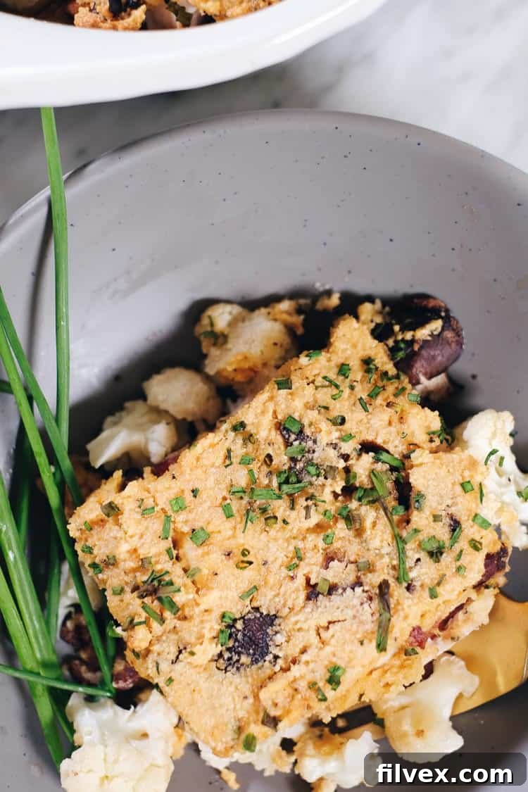 Close-up of a serving of Loaded Cauliflower Casserole in a bowl, showing the texture of the topping and ingredients