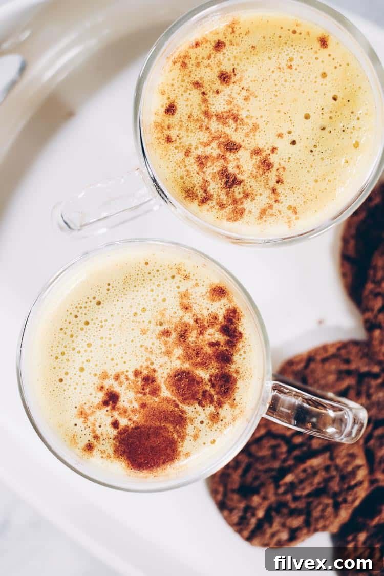 A beautifully styled dairy-free Pumpkin Turmeric Latte, perfect for snuggling up. This caffeine-free beverage blends favorite fall flavors and is Paleo, Vegan, and Refined Sugar-Free. Learn how to make this comforting drink on realsimplegood.com.