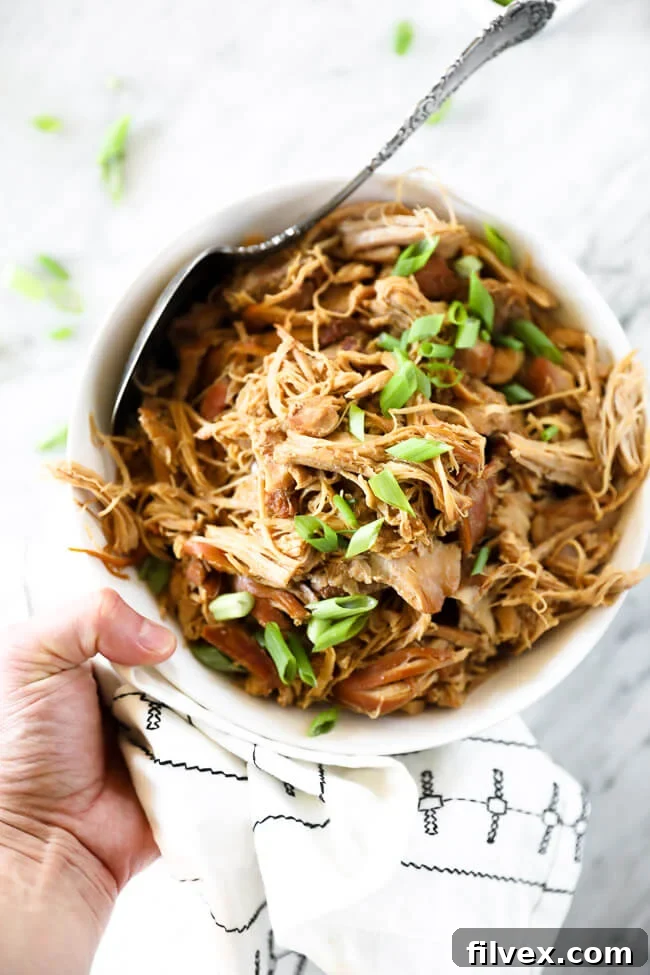 Vertical overhead image of holding bowl for honey garlic chicken with chopped green onion sprinkled on top. 
