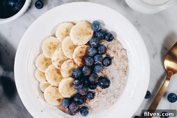 A close-up shot of Paleo Overnight Oats topped with fresh berries, banana slices, and a drizzle of nut butter, highlighting its creamy and appealing texture. This image inspires healthy and easy breakfast ideas.