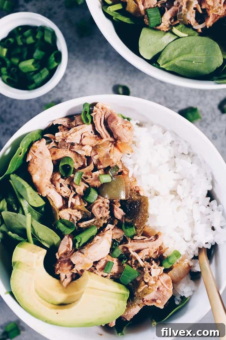 bowl of cooked chicken over greens and rice