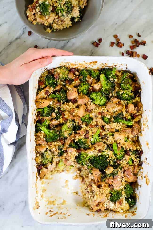 A beautiful casserole dish filled with healthy chicken and broccoli casserole, featuring crispy bacon and creamy cauliflower rice, ready to be served. 