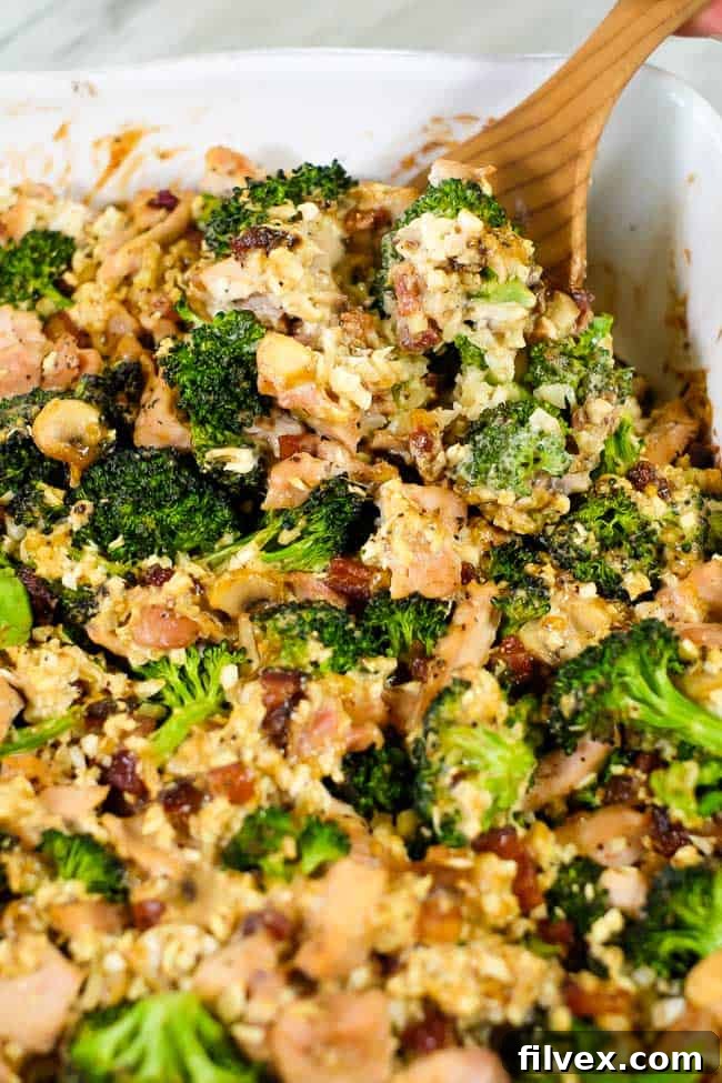 Close-up view of the hearty chicken and broccoli casserole with bacon and cauliflower rice, highlighting the rich, creamy sauce and appetizing texture. 