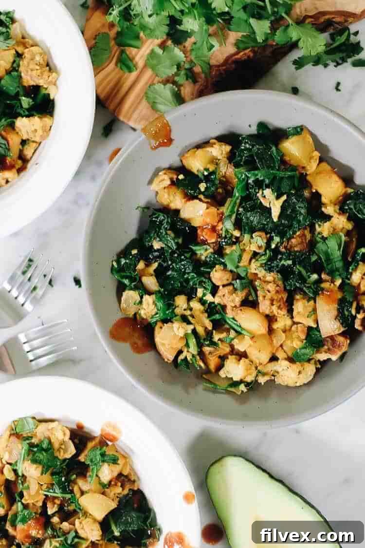 A beautifully presented bowl of Chorizo and Eggs, topped with fresh avocado and cilantro, ready to be enjoyed.