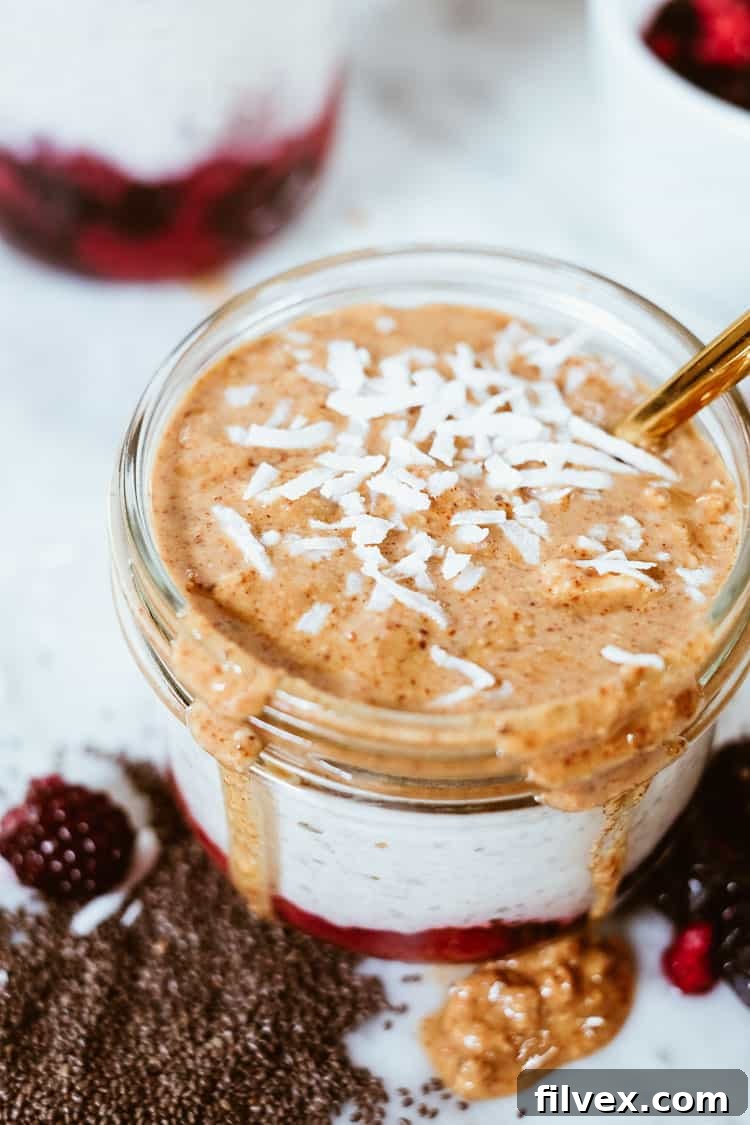 Close-up angle shot of "PB" and Jelly Overnight Oats, showcasing the layers of fruit, oats, and nut butter.
