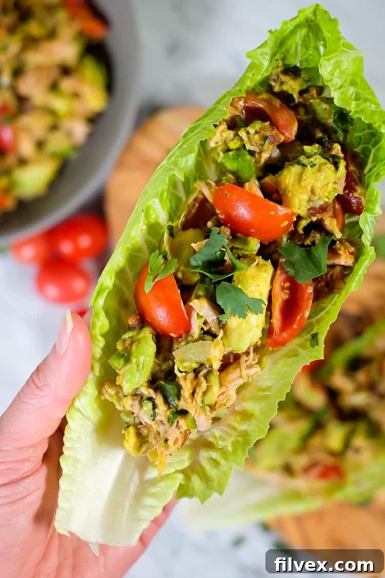 A vibrant bowl of creamy chicken avocado salad with crispy bacon bits, fresh cilantro, red onion, and diced tomatoes. This healthy salad is perfect for Paleo, Whole30, and Keto diets and can be made quickly or prepped ahead for easy meals.