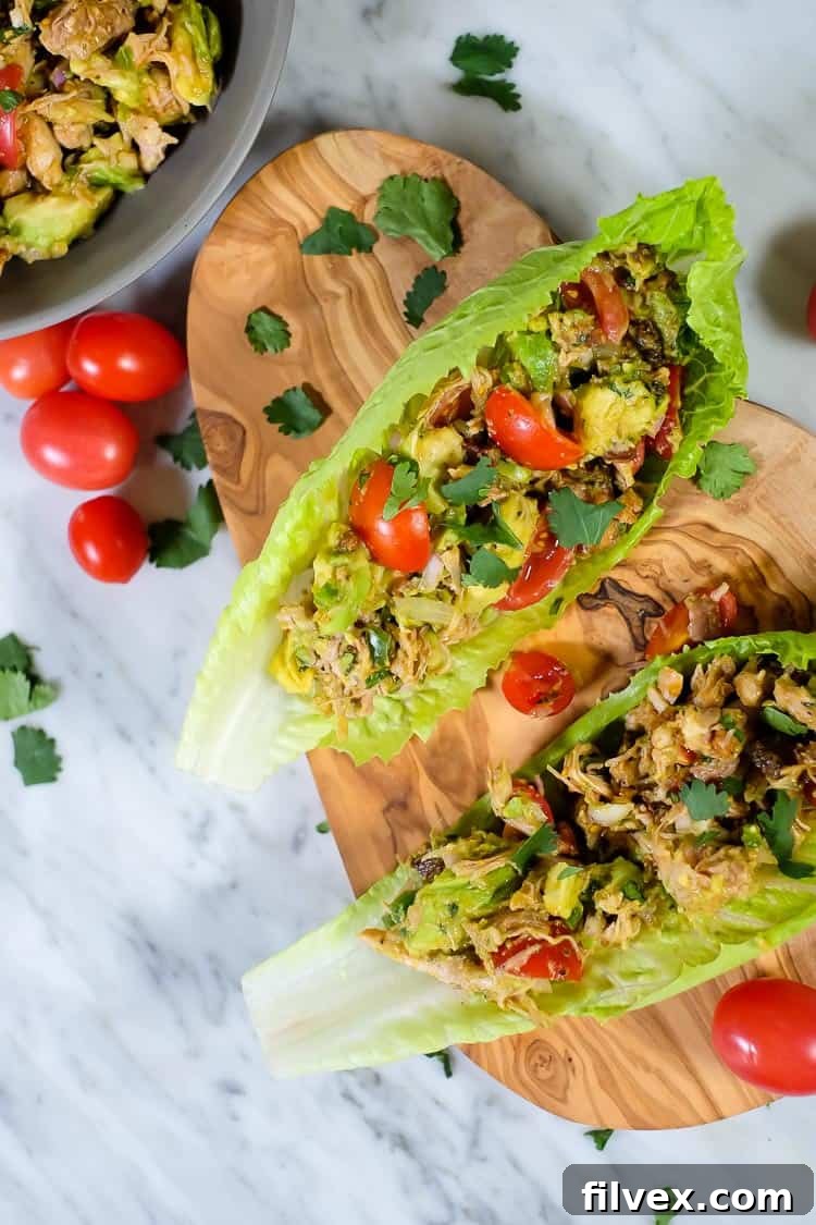 A serving of chicken avocado salad with bacon nestled in a crisp lettuce cup, ready to be enjoyed as a healthy and quick meal.
