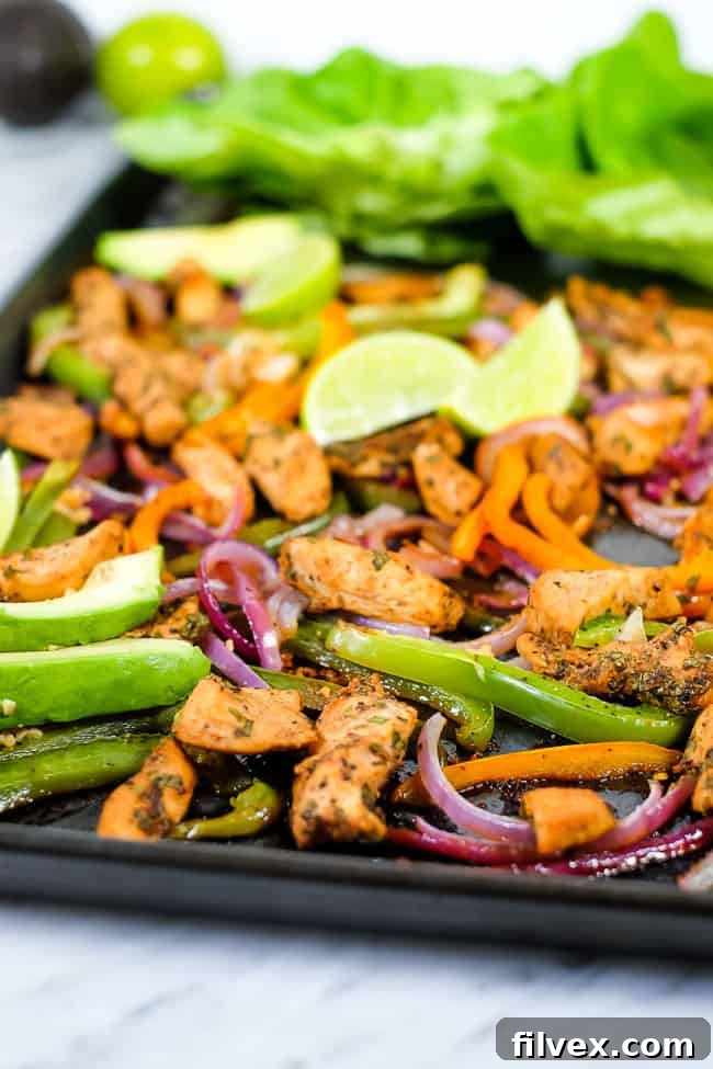 Sheet pan chicken fajita bake with avocado, lime, cilantro and butter lettuce on sheet pan.