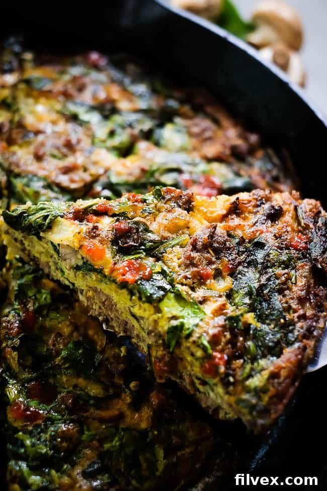 Crustless spinach quiche angle with slice being picked up, showcasing fluffy texture and crispy edges