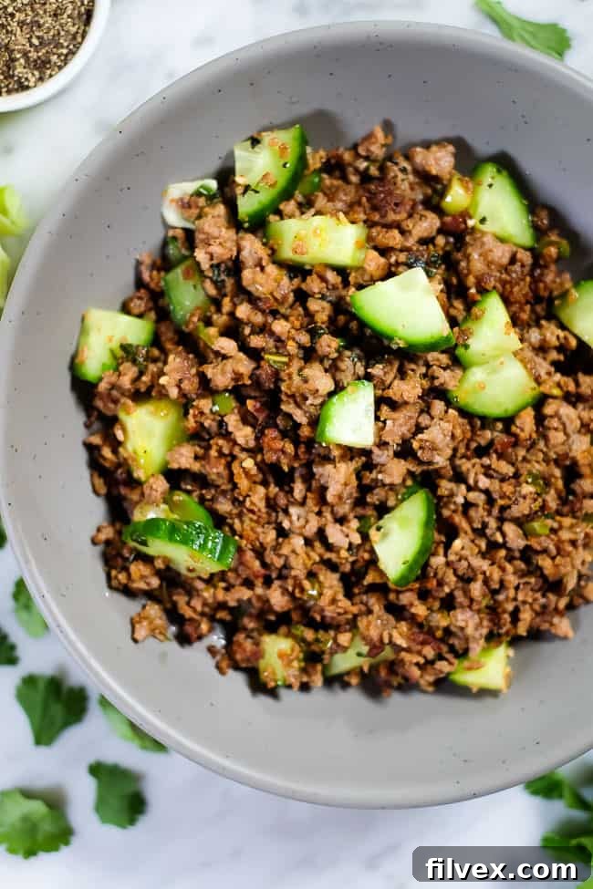 This is a Thai larb recipe with ground pork or chicken, cucumber and some seasonings. Shown served in a bowl. 