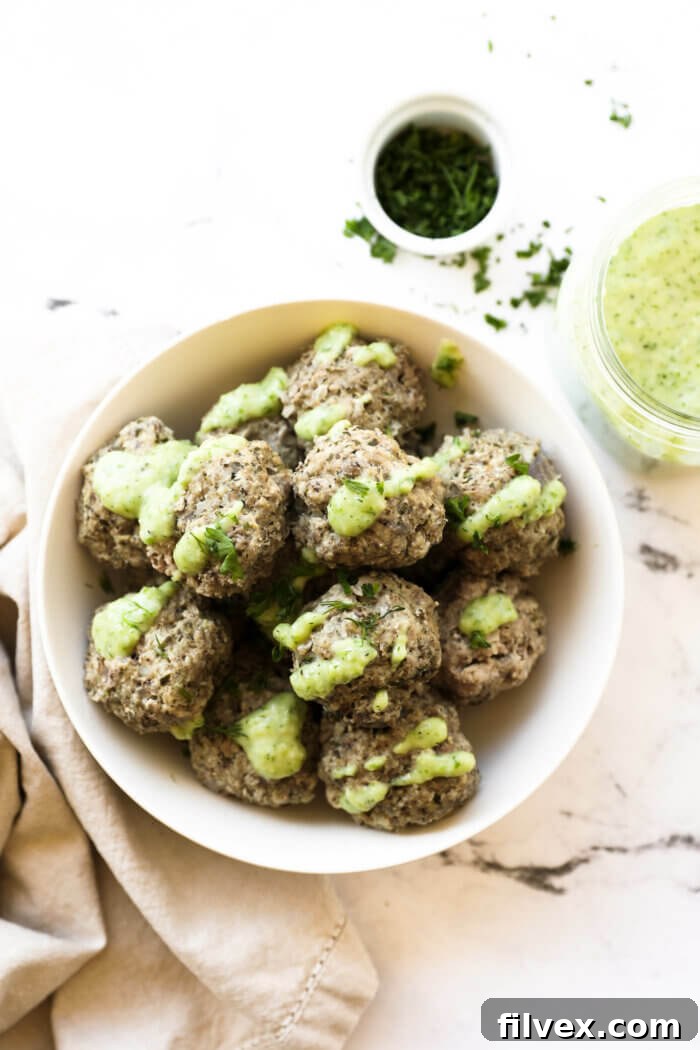 Close-up overhead shot of keto-friendly Greek meatballs served with a creamy dairy-free tzatziki sauce and fresh herbs, ready to eat.