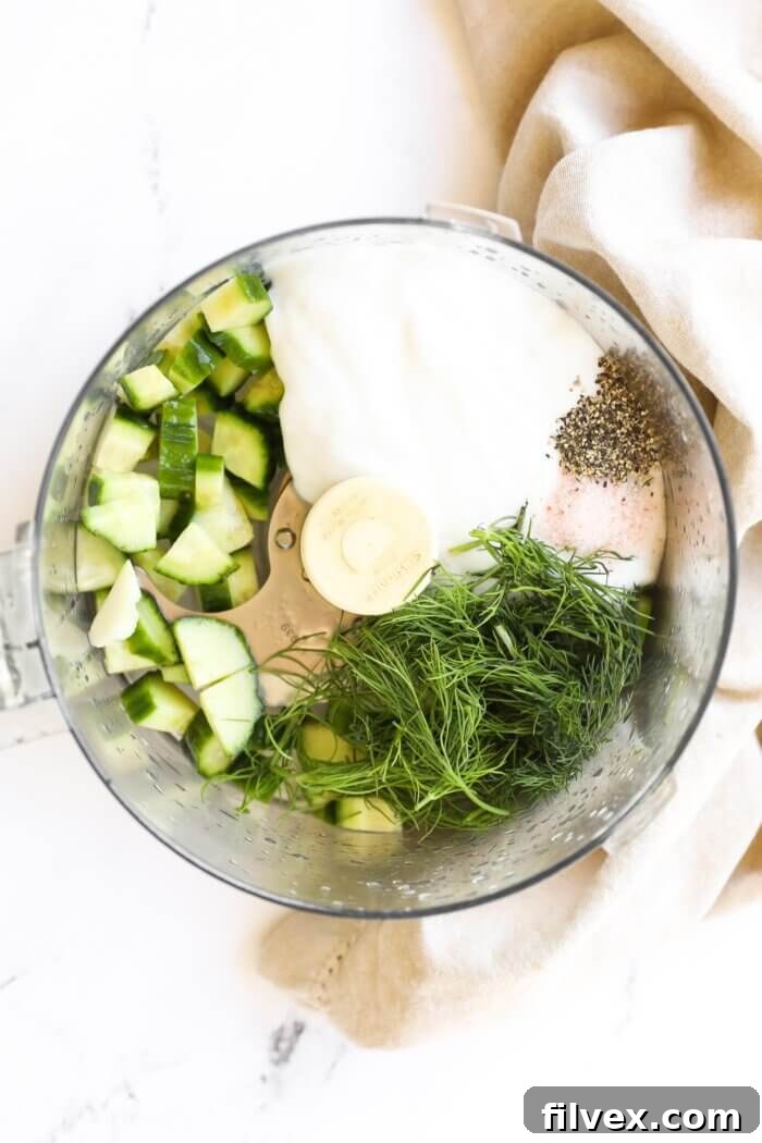 Cooked Greek meatballs, still hot from the Instant Pot, with a generous drizzle of dairy-free tzatziki sauce and fresh herbs for garnish.
