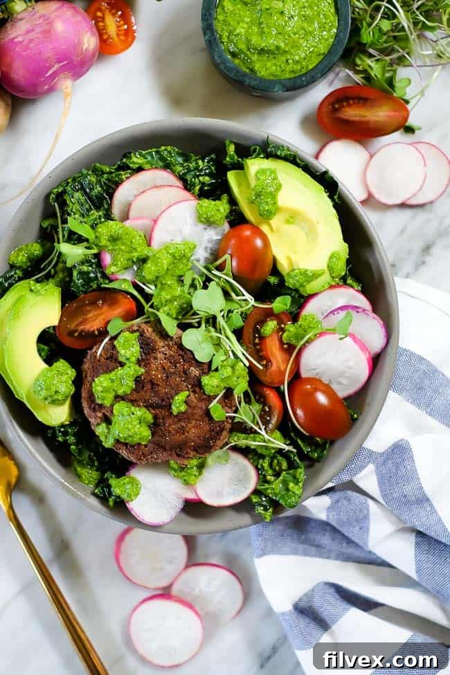 Overhead shot of a ready-to-eat Pesto Burger Salad bowl, showcasing the arrangement of ingredients for a healthy and satisfying meal.