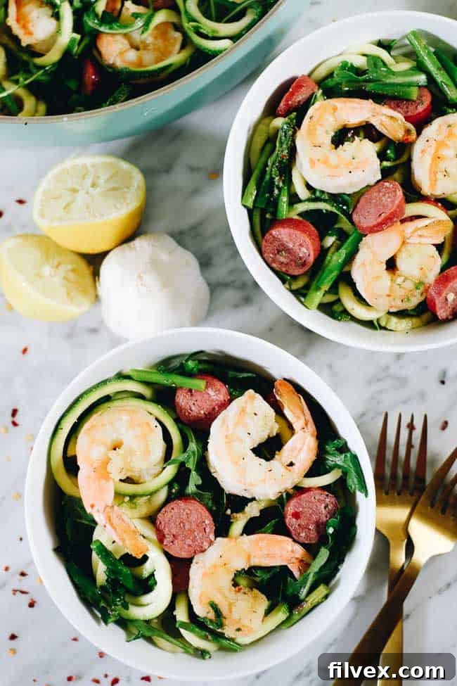 Lemon Garlic Shrimp Pasta in two bowls and skillet with lemon and garlic on the side. 
