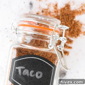 Close-up of Homemade Taco Seasoning (Whole30 + Paleo) in a jar with a wooden spoon