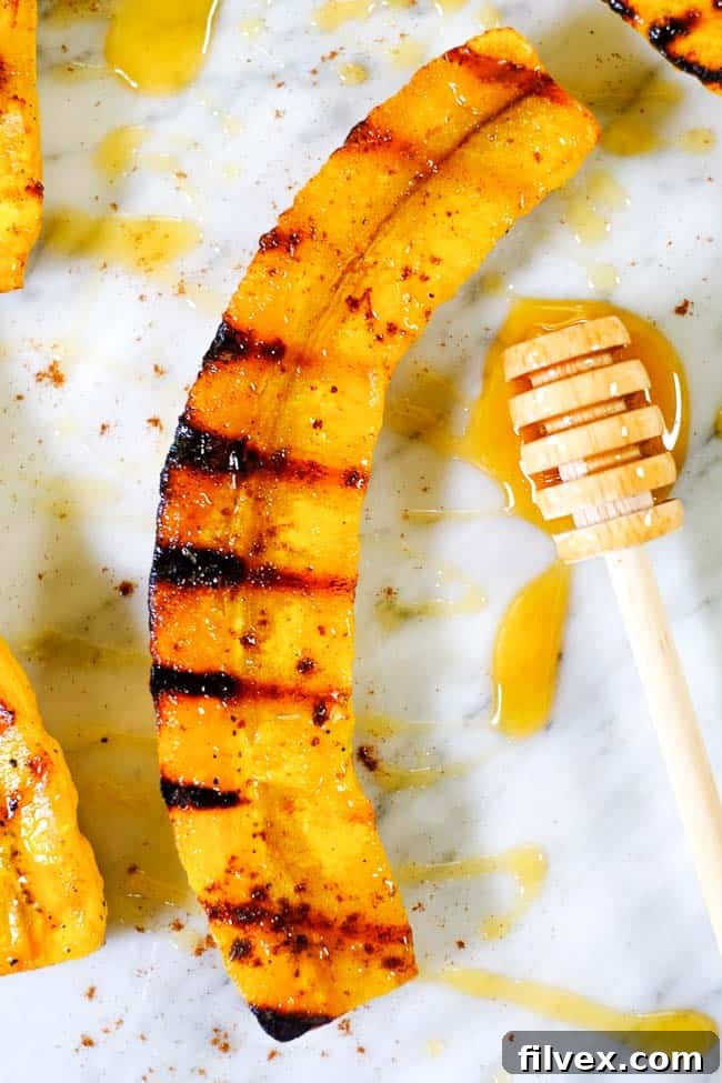 Close-up shot of a single grilled plantain, glistening with honey and a dusting of cinnamon, ready to be enjoyed.