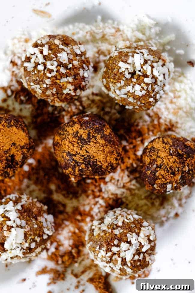 Close-up of Fig and date bliss balls, some coated in shredded coconut, others in rich raw cacao powder.
