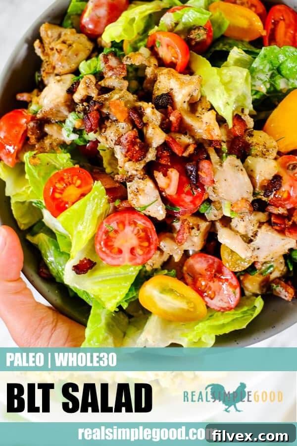 A close-up, top-down shot of a BLT salad bowl, ready to be enjoyed, with a focus on the vibrant ingredients and fresh garnish.