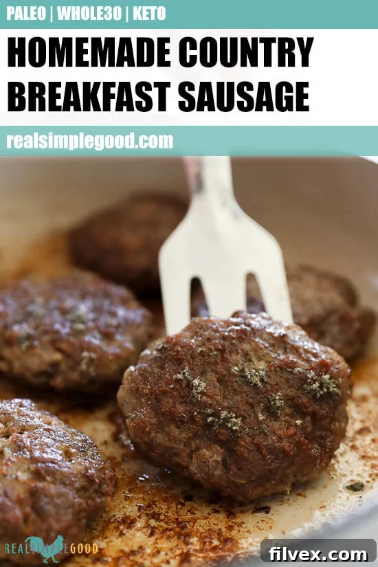 A beautifully composed shot of cooked homemade breakfast sausage patties alongside fresh ingredients like sage, perfect for a rustic breakfast.