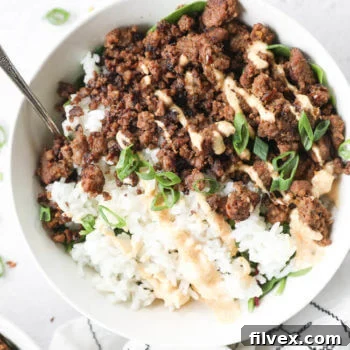 Close up overhead shot of single korean beef bowl with rice and spicy mayo topping