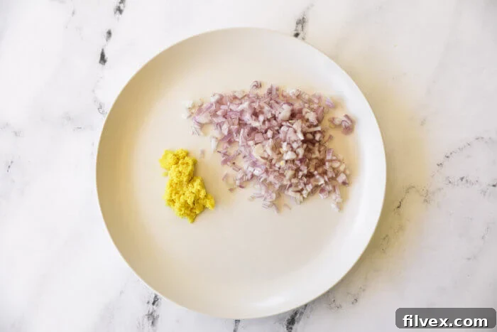 Chopped shallot and grated ginger on a white plate