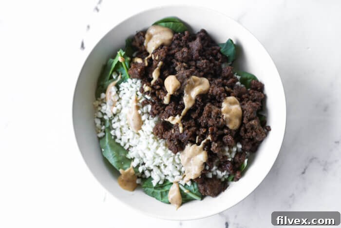 Korean beef bowl with bed of greens and cauliflower rice with spicy mayo on top