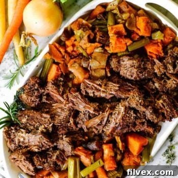 Shredded instant pot pot roast on a platter with carrots and celery