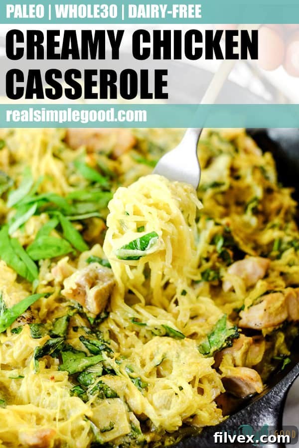 Creamy chicken casserole in a cast iron skillet with a fork scooping out a bite, showcasing the rich texture and readiness to eat.