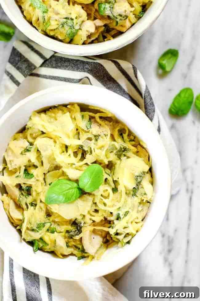 Two bowls of creamy chicken casserole, each garnished with fresh basil and served alongside a striped napkin. Emphasizes the appealing presentation and shareable nature of the dish.