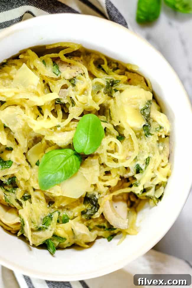 A single bowl of creamy chicken casserole, garnished generously with fresh basil, presented on a light-colored surface. The focus is on the inviting texture and garnish.