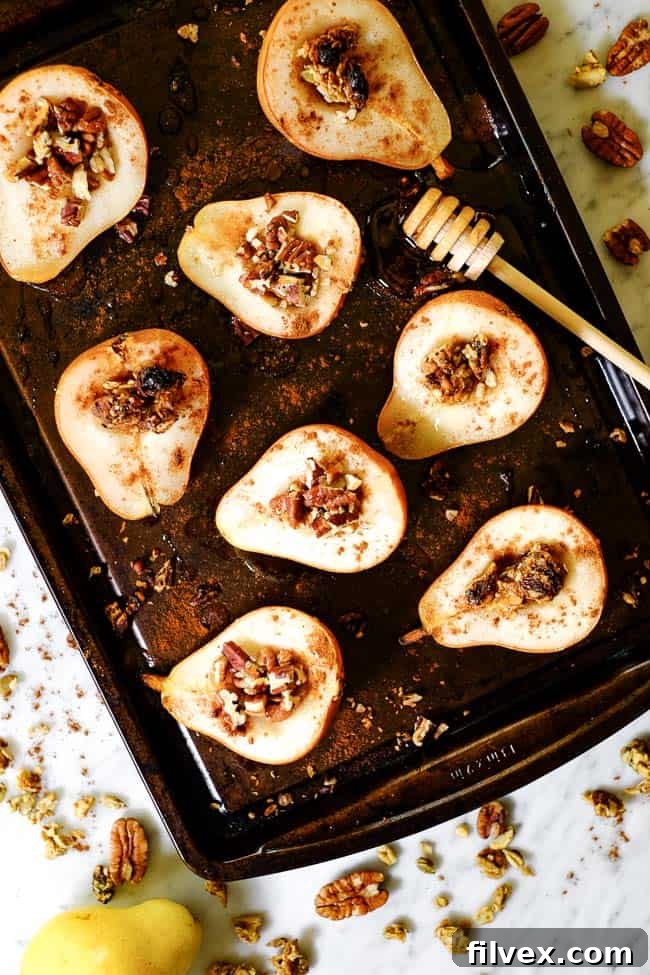 Easy baked pears on a cookie sheet with cinnamon, chopped nuts, granola and honey. 