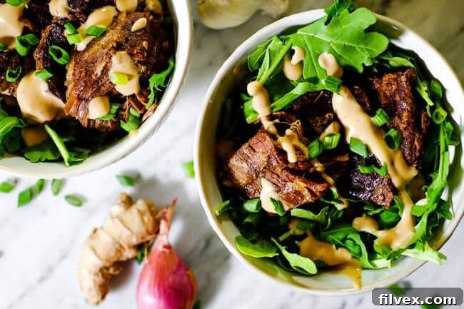 Instant pot short ribs in two bowls with greens, mayo sauce and chopped green onion. Extra green onion, garlic, shallot and ginger on the table.