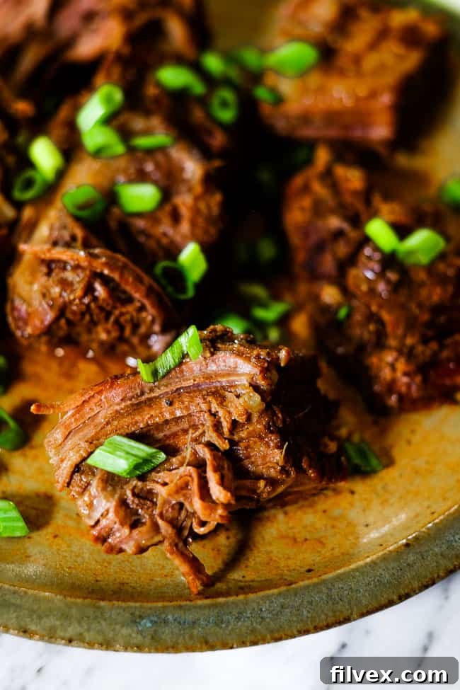 Instant pot short ribs on a plate garnished with chopped green onion.