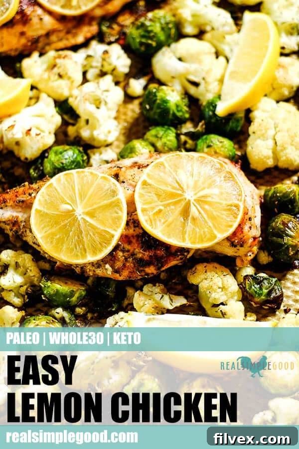 Close up of easy lemon chicken with roasted brussels sprouts and cauliflower on a sheet pan with lemon slices. Long pin for pinterest. 