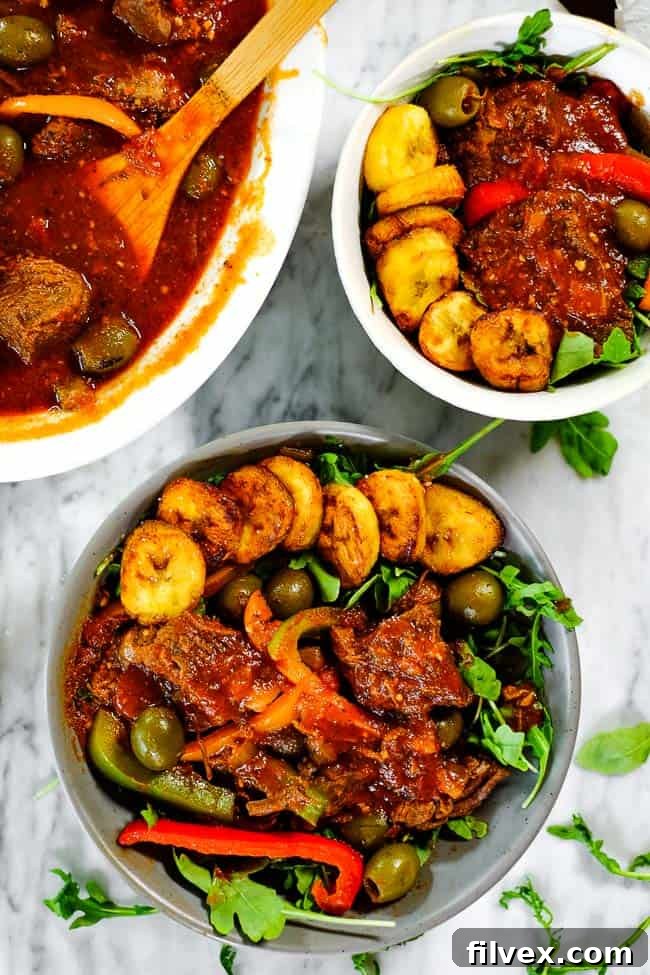 Close-up of Ropa Vieja served in individual bowls, featuring a generous portion of the shredded beef stew, fresh green salad, and perfectly fried plantains.